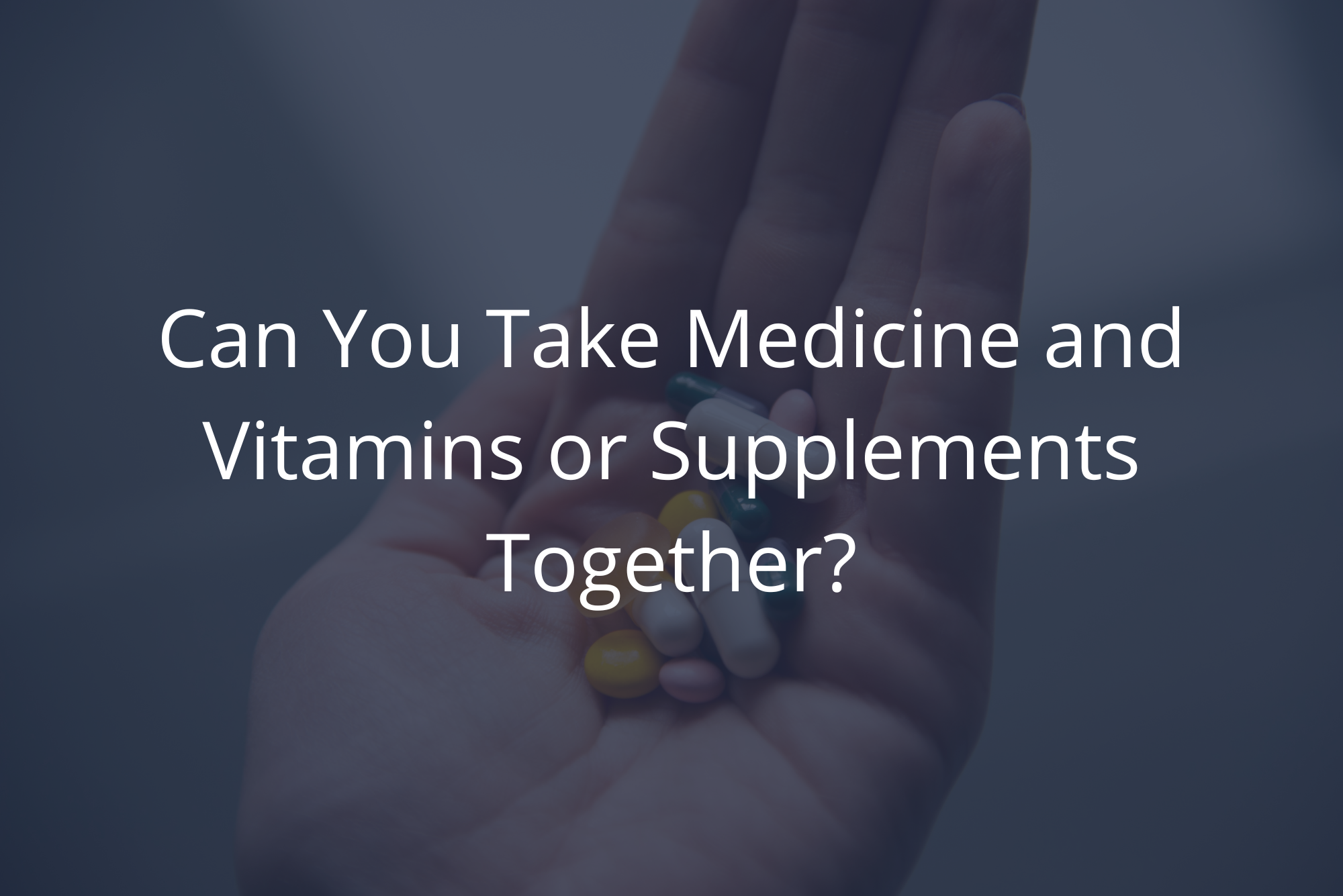 Someone holds a handful of their medicine and vitamins together.