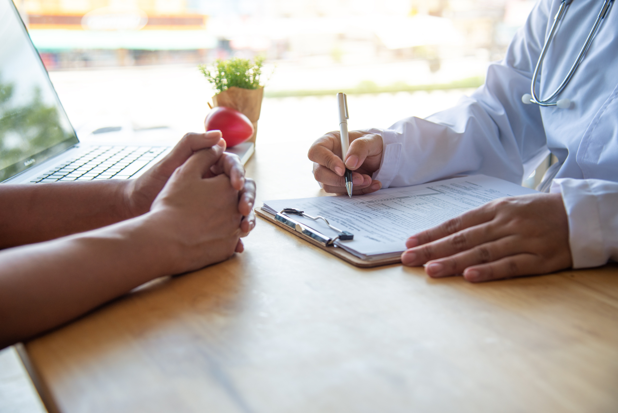 A physician goes through a patient's medical history at a desk during an executive physical.