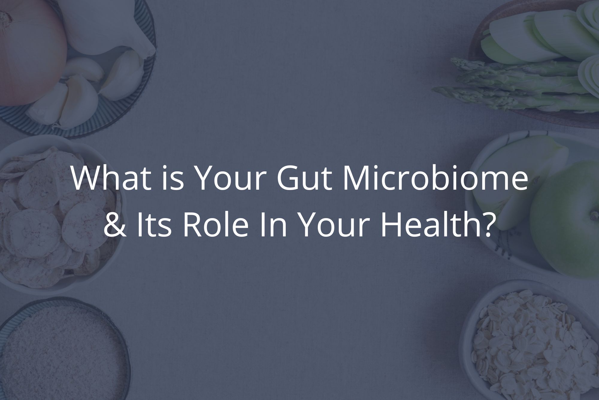 Food helpful for your human microbiome is spread out on a white table in various bowls.