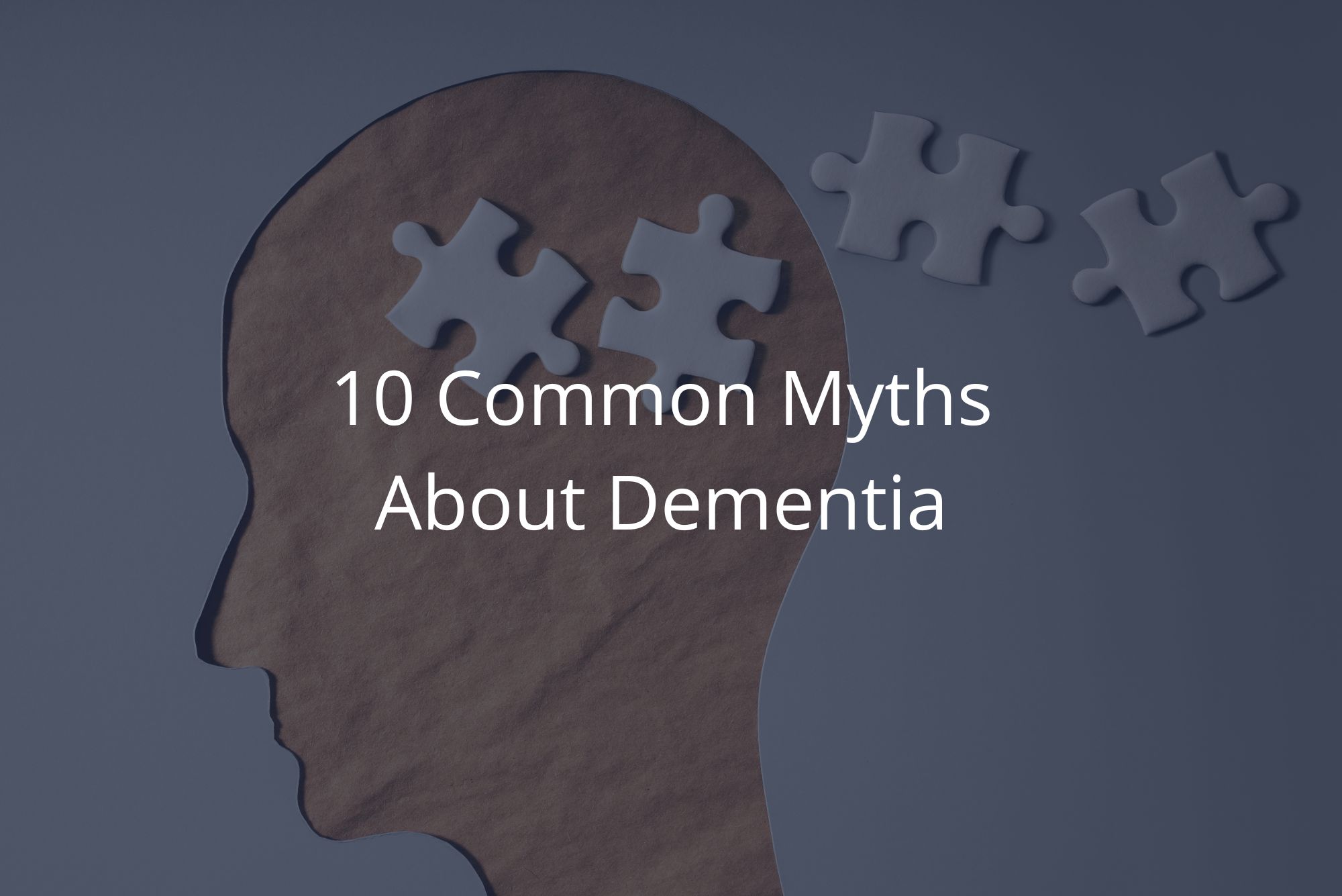 A paper cut-out of a head with 4 white puzzle pieces represents common myths about dementia with a dark overlay.