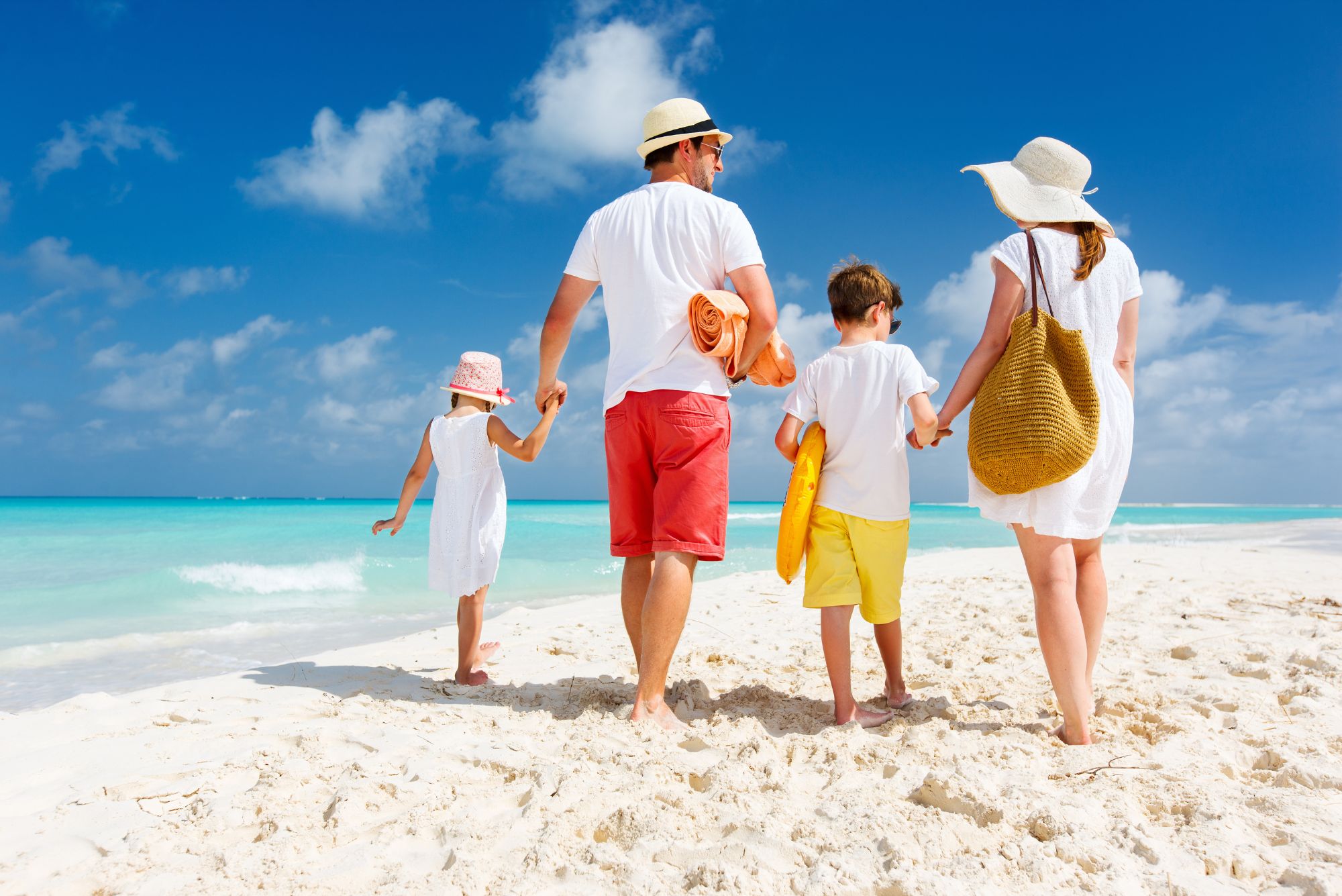 A family walks along the shoreline, unaware of the beach danger in Florida.