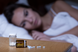 Two bottles of sleeping pills are on a nightstand, and a woman who googled 