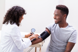 A nurse checks the blood pressure of a young man who wants to know what a good blood pressure is.