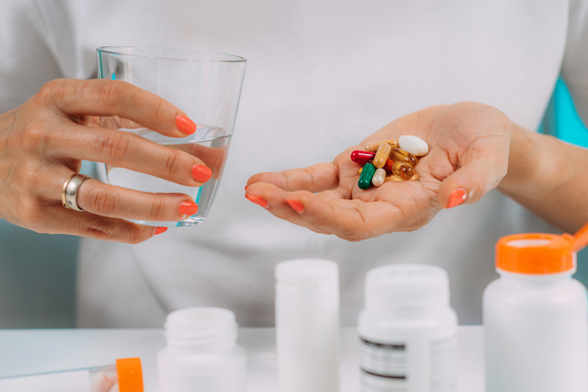 A woman holds a glass of water to help her with taking megadoses of vitamins.