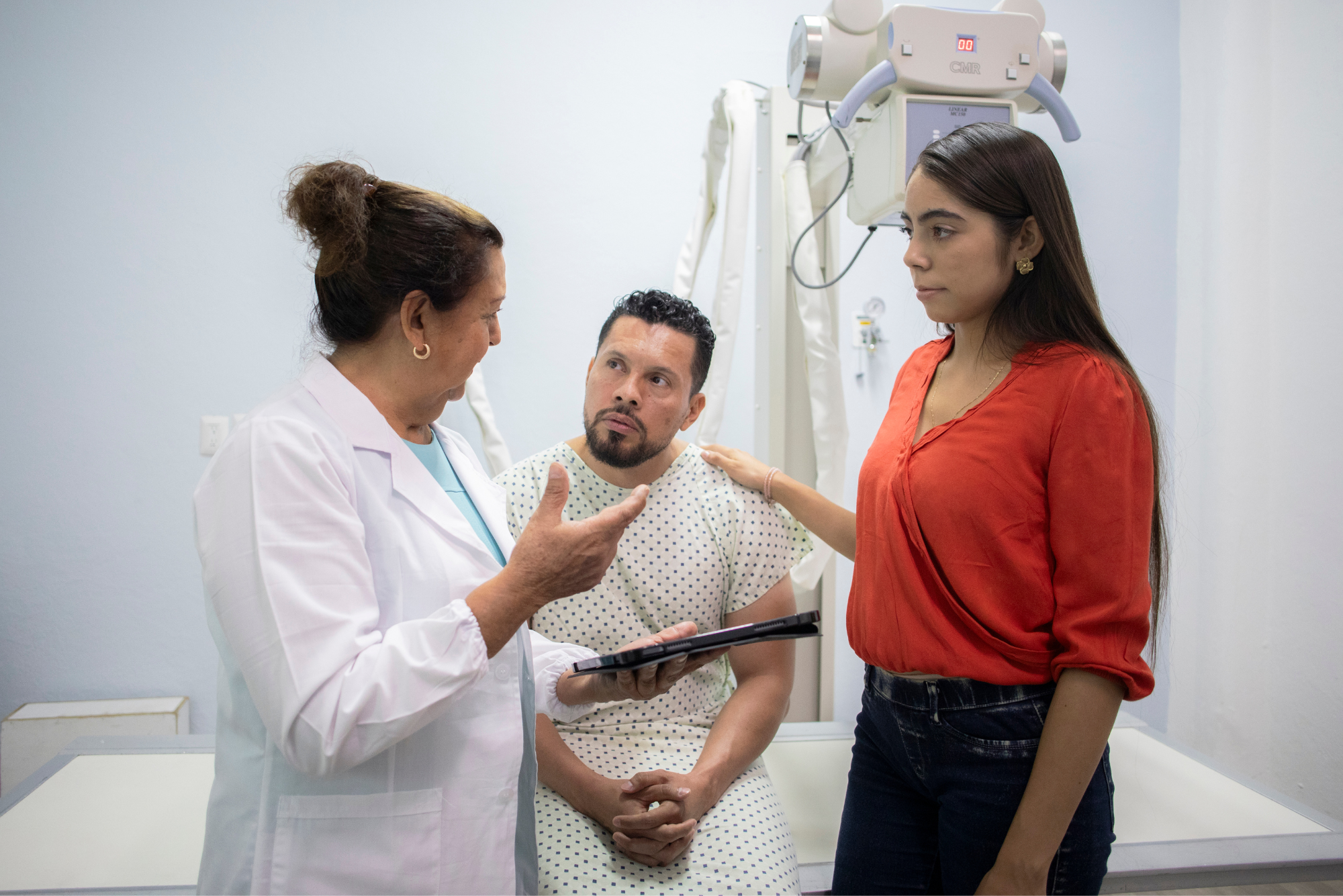 A woman speaks to her husband’s doctor about his medical treatment plan because he brought her to his appointment.