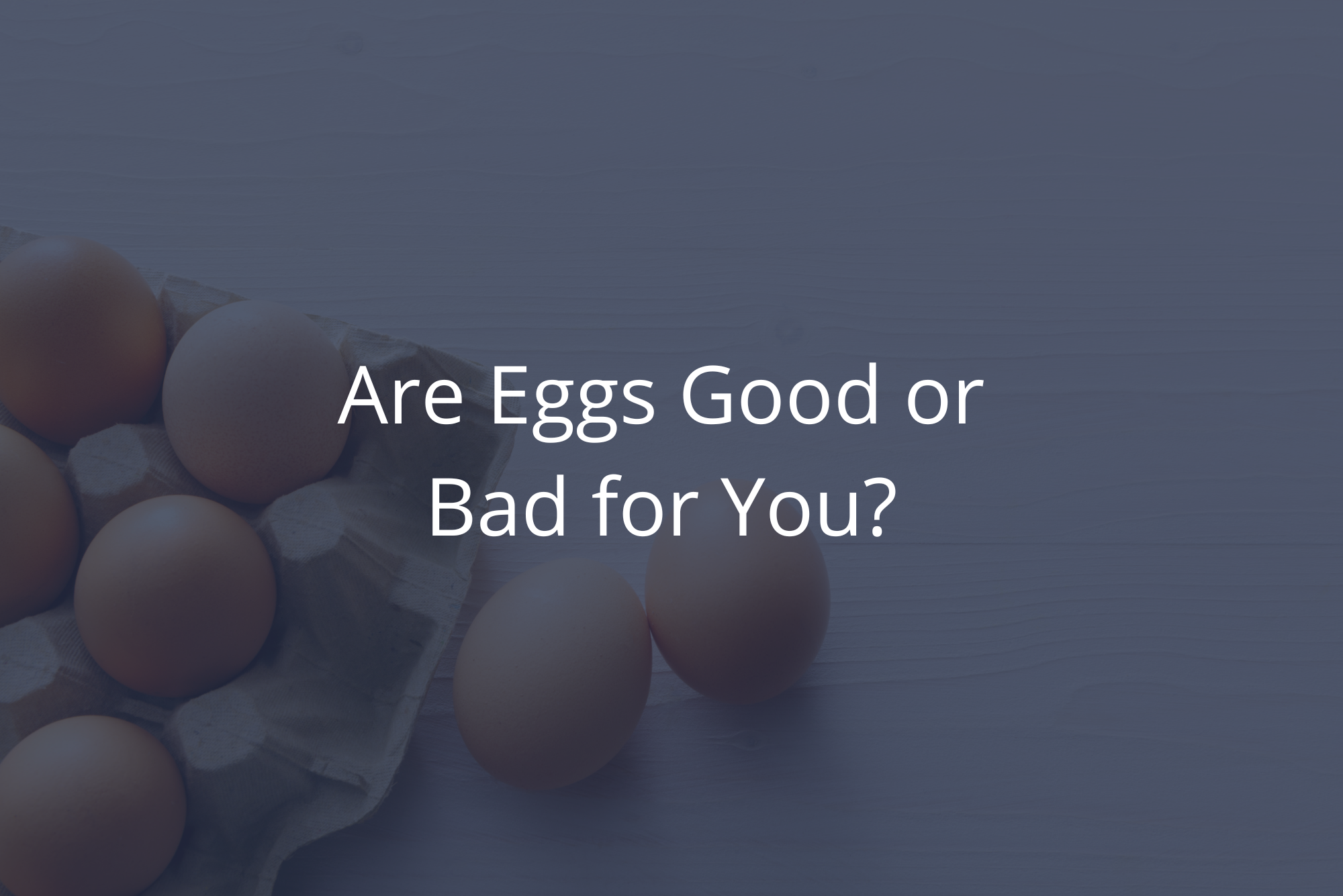 A carton of fresh brown eggs sits on a wooden table top, representing the nutritional value of eggs.