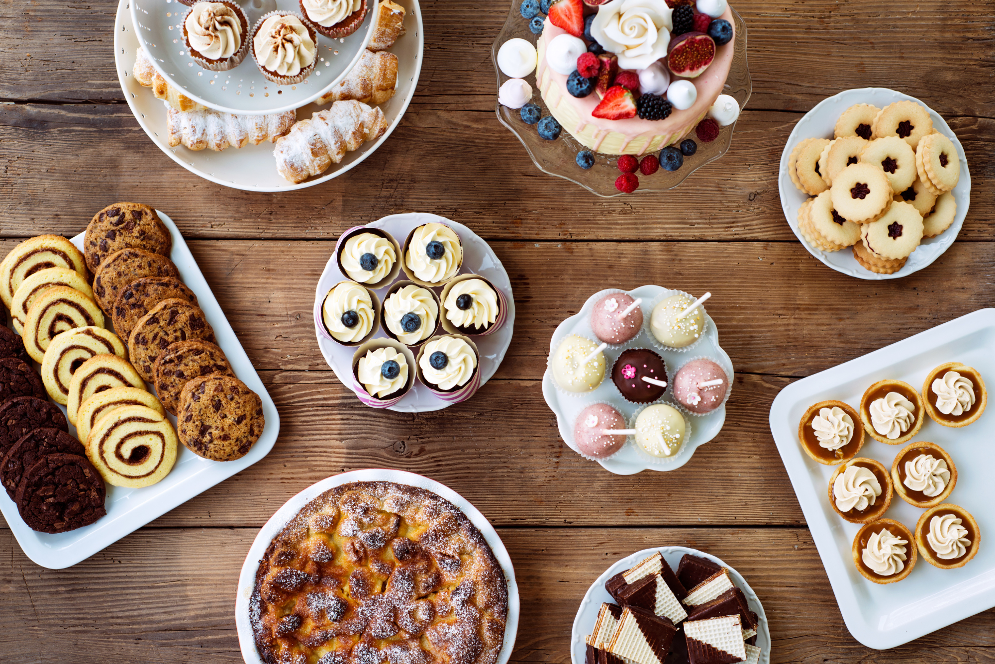 An overhead view of a table full of assorted desserts, representing the benefits of enjoying dessert.